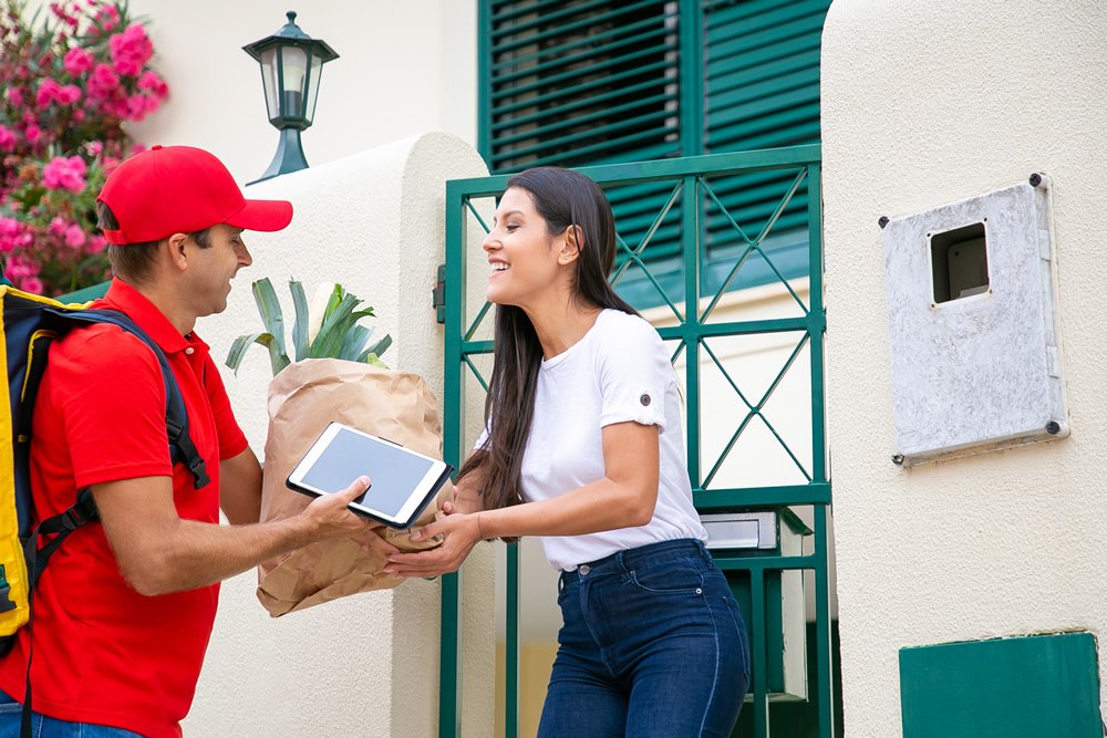 Delivery partner handing a parcel to a customer